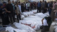 Seorang warga memeluk erat jenazah anaknya di kawasan Rumah Sakit Al-Aqsa, Jalur Gaza. Sementara itu sejumlah warga tampak berkerumun di sekitar korban tewas akibat serangan Israel.