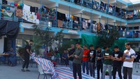 Warga melaksanakan salat berjamaah di halaman sekolah.  