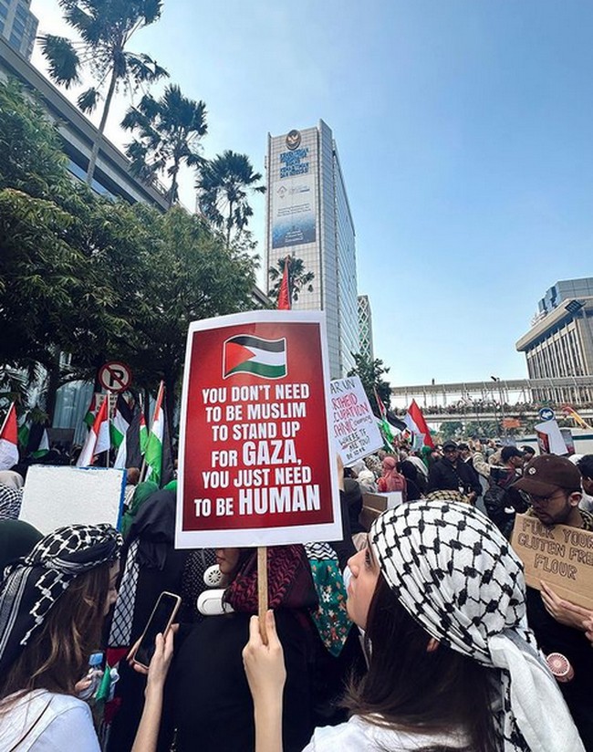 Dalam aksinya itu, kekasih Rizky Nazar itu membawa spanduk berbahasa Inggris yang diterjemahkan menjadi: “Kamu tidak perlu menjadi muslim untuk membela Gaza, kamu hanya perlu menjadi manusia. Foto: dok. Instagram/@syifahadju