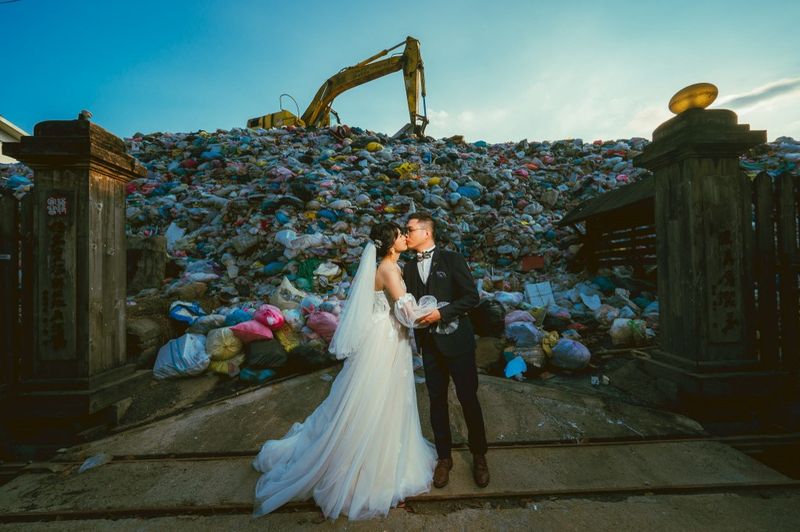 TAIWAN-ENVIRONMENT-WASTE Foto selebaran ini diambil pada 14 Oktober 2023 dan dirilis oleh Owen Kang pada 20 Oktober 2023 memperlihatkan Iris Hsueh (Kiri) dan tunangannya Ian Ciou berpose untuk difoto di depan tumpukan sampah di Kotapraja Puli, Kabupaten Nantou. Pasangan asal Taiwan ini mengenakan busana pernikahan mereka dan berpose di depan tumpukan sampah -- foto ini ingin ditunjukkan kepada para tamu untuk mencegah mereka menghasilkan sampah.