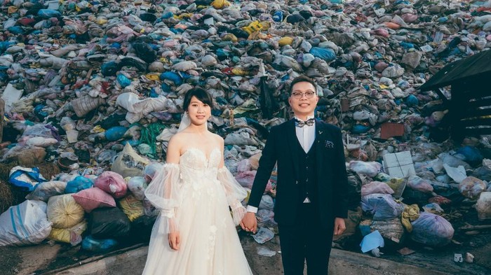 Foto selebaran ini diambil pada 14 Oktober 2023 dan dirilis oleh Owen Kang pada 20 Oktober 2023 memperlihatkan Iris Hsueh (Kiri) dan tunangannya Ian Ciou berpose untuk difoto di depan tumpukan sampah di Kotapraja Puli, Kabupaten Nantou. Pasangan asal Taiwan ini mengenakan busana pernikahan mereka dan berpose di depan tumpukan sampah -- foto ini ingin ditunjukkan kepada para tamu untuk mencegah mereka menghasilkan sampah.