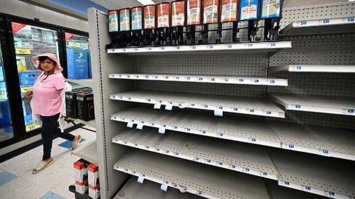 A woman browses through what items remain on near empty shelves at a Rite Aid store in Alhambra, California, on October 18, 2023, that is due for closure next Monday. The US pharmacy chain this week filed for Chapter 11 and plans to close almost 100 stores nationwide, including 31 in California, as part of its restructuring plan after filing for bankruptcy. (Photo by Frederic J. BROWN / AFP)