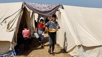 Warga Gaza tinggal di kamp pengungsian yang didirikan PBB di wilayah selatan Gaza.  