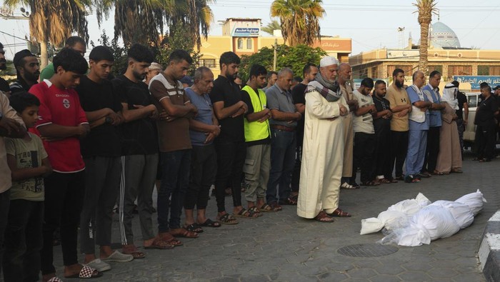 Palestinians pray by the bodies of people killed in the Israeli bombardment in Deir Al-Balah, Gaza Strip, Monday, Oct. 23, 2023. (AP Photo/Adel Hana)