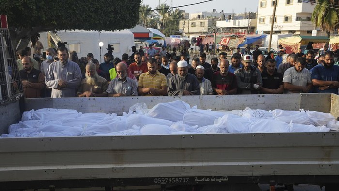 Palestinians pray by the bodies of people killed in the Israeli bombardment in Deir Al-Balah, Gaza Strip, Monday, Oct. 23, 2023. (AP Photo/Adel Hana)