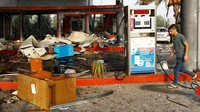 Atap pom bensin yang hancur tampak berserakan di lantai.  