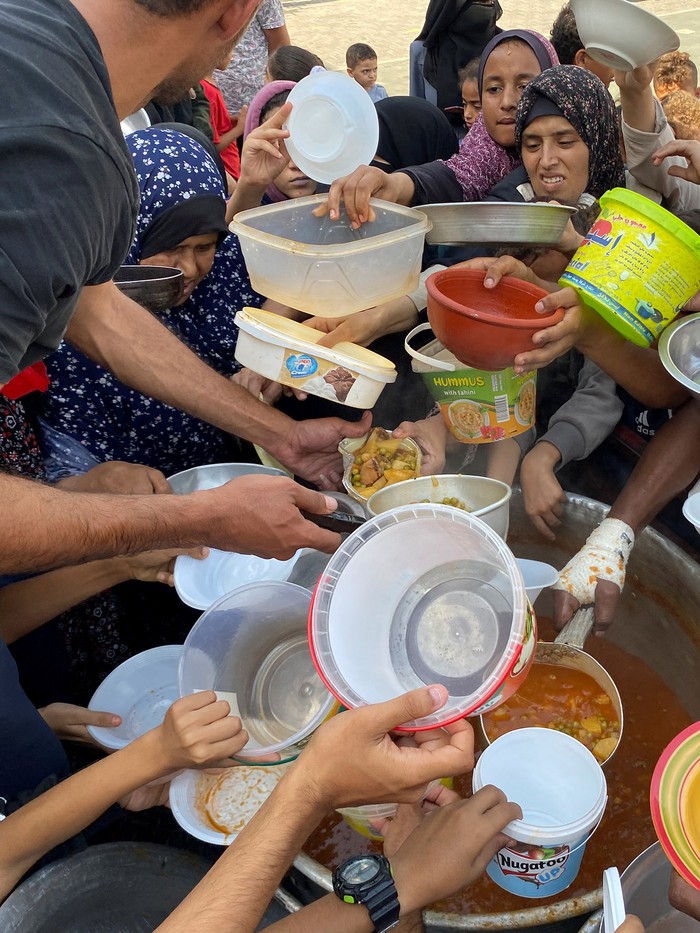 Potret Pengungsi Palestina Antre Bantuan Makanan Warga Palestina yang mengungsi akibat serangan Israel ke Jalur Gaza menerima bantuan makanan, Senin (2310) waktu setempat.