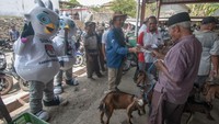Warga menerima selebaran tentang Pemilu 2024 yang diberikan oleh petugas KPU berkostum maskot Pemilu.