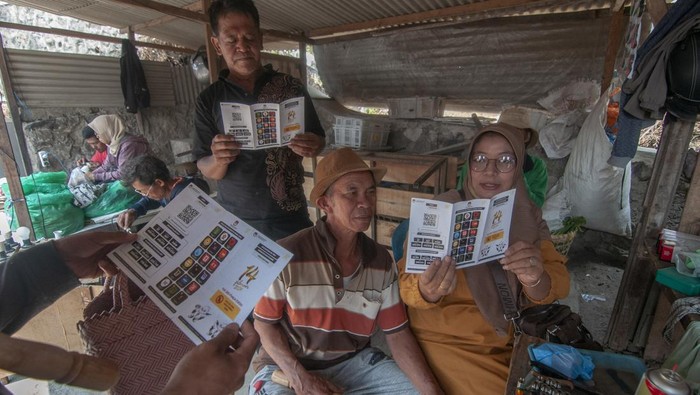 Warga membaca selebaran tentang Pemilu 2024 saat Sosialisasi Pemilu 2024 di Pasar Cepogo, Boyolali, Jawa Tengah, Selasa (24/10/2023). Sosialisasi yang dilakukan oleh KPU Kabupaten Boyolali itu bertujuan untuk mengajak masyarakat menggunakan hak suaranya pada Pemilu 2024 yang akan dilaksanakan 14 Februari 2024. ANTARA FOTO/Aloysius Jarot Nugroho/aww.
