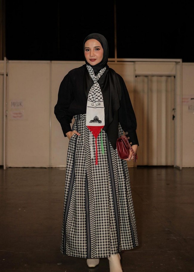 Sebagai pernyataan dukungan untuk Palestina, istri Irwansyah ini memakai scarf motif fishnet yang umum ditemukan pada keffiyeh Palestina. Keffiyeh merupakan selembar kain yang biasa dikenakan warga Palestina sebagai identitas negara. Foto: Instagram/@zaskiasungkar15