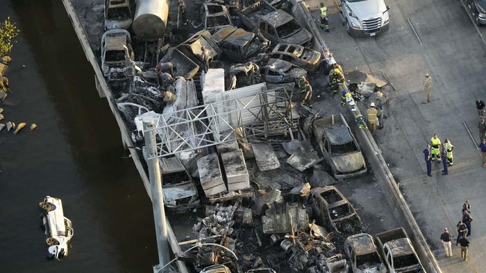 A towing company removes a burnt vehicle from Interstate-55 near Manchac, Tuesday, October 24, 2023.  Authorities say at least seven people were killed Monday after a “superfog” of smoke from south Louisiana marsh fires and dense fog caused multiple massive car crashes involving 158 vehicles. (Brett Duke/The Times-Picayune/The New Orleans Advocate via AP)