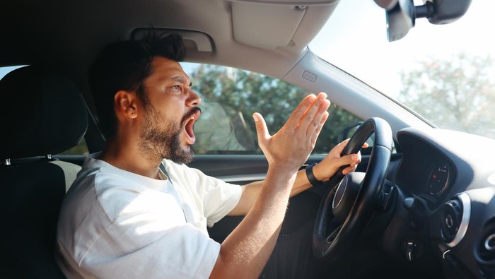 Angry screaming male driver driving car. Driving training and fear of traffic car traffic concept