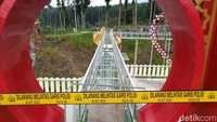 Tinggi jembatan kaca ke dasar sekitar 15 meter. Di bawah jembatan terdapat tanah yang berlapis rumput tipis. Pecahan kaca berserakan di dasar tersebut. Foto: Anang Firmansyah/detikJateng  