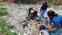warga juga mengais air dari sungai yang mengering untuk mandi dan mencuci pakaian.