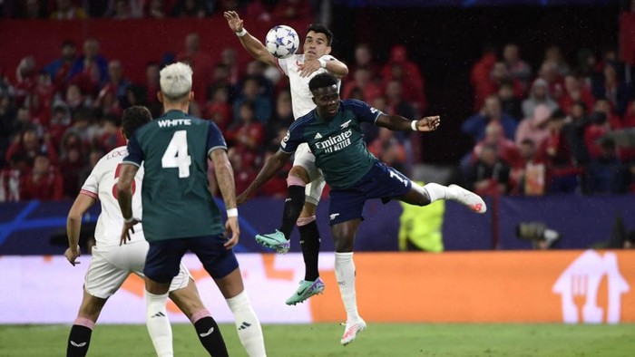 Sevillas Argentinian defender #19 Marcos Acuna (TOP) and Arsenals English midfielder #07 Bukayo Saka vie for a header during the UEFA Champions League 1st round day 3 Group B football match between Sevilla FC and Arsenal at the Ramon Sanchez Pizjuan stadium in Seville on October 24, 2023. (Photo by CRISTINA QUICLER / AFP)