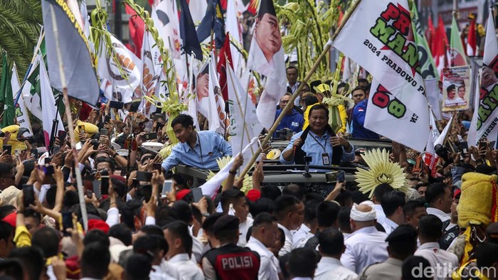 Prabowo Subianto dan Gibran Rakabuming Raka yang menaiki mobil Maung diarak menuju Gedung KPU, Jakarta, Rabu (25/10). Mereka akan mendaftarkan diri sebagai pasangan capres-cawapres.