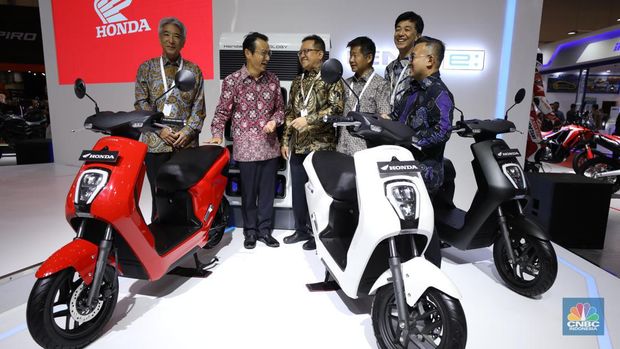 Pengunjung melihat motor listrik dalam ameran Indonesia Motorcycles Show atau IMOS+ 2023 di ICE BSD, Tangerang, Rabu (25/10/2023). (CNBC Indonesia/Tri Susilo)
