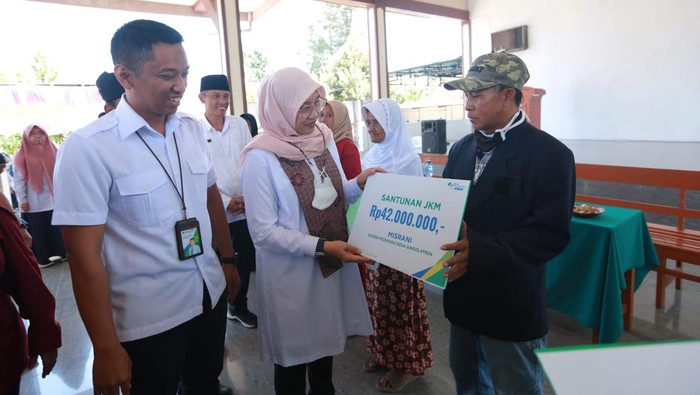 Bupati Ipuk Fiestiandani saat memberikan premi BPJS Ketenagakerjaan kepada ahli waris 2 kader posyandu di Banyuwangi.
