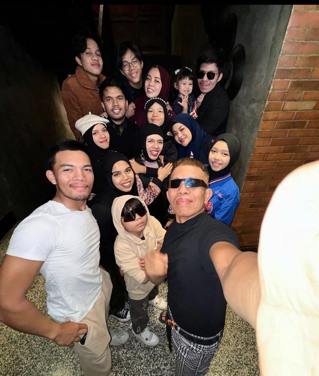 Potret Halilintar Asmid bersama keluarganya. Mengenakan kaca mata hitam, Asmid memadukan kaos hitam dengan celana panjang kotak-kotak berwarna senada dan ikat pinggang. Foto: Instagram/@halilintarasmid