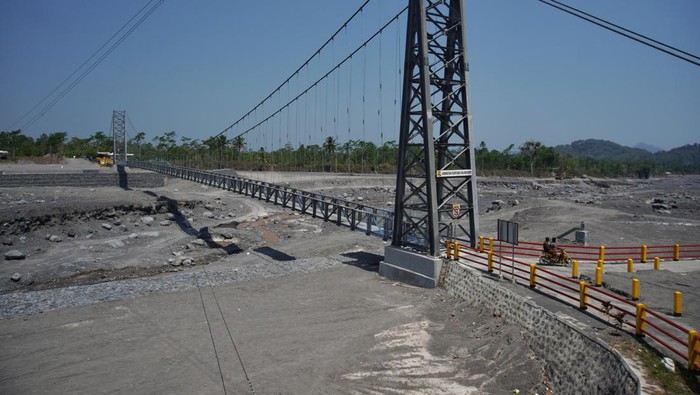 Pengendara melintas di atas Jembatan Gantung Kaliregoyo, Lumajang, Jawa Timur, Kamis (26/10/2023). Jembatan penghubung antardusun yang sempat tidak dapat dilintasi karena putus akibat diterjang banjir lahar hujan Gunung Semeru pada (7/7) tersebut telah diperbaiki dengan total anggaran Rp7 miliar sehingga telah berfungsi kembali. ANTARA FOTO/Irfan Sumanjaya/nym.