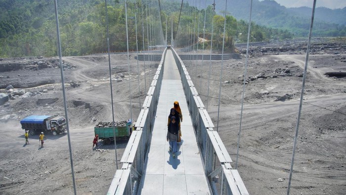 Jembatan Gantung Kaliregoyo berfungsi kembali Pengendara melintas di atas Jembatan Gantung Kaliregoyo, Lumajang, Jawa Timur, Kamis (26/10/2023). Jembatan penghubung antardusun yang sempat tidak dapat dilintasi karena putus akibat diterjang banjir lahar hujan Gunung Semeru pada (7/7) tersebut telah diperbaiki dengan total anggaran Rp7 miliar sehingga telah berfungsi kembali. ANTARA FOTO/Irfan Sumanjaya/nym.