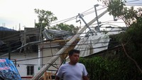 Badai juga mengakibatkan tiang listrik ambruk hingga menimpa kios yang berada di pinggir jalan. Reuters/Henry Romero.  