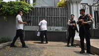 Tampak polisi membawa masuk sebuah koper berwarna gelap dan sebuah mesin printer hitam. Kemudian dua orang berbaju merah dan abu-abu membawa tas berisi kunci masuk ke rumah. (ANTARA FOTO/Aprillio Akbar) 