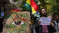 Pengunjuk rasa memegang papan bertuliskan dalam bahasa Spanyol Tanpa hutan tidak ada kehidupan dan Cukup membakar Bolivia. 
