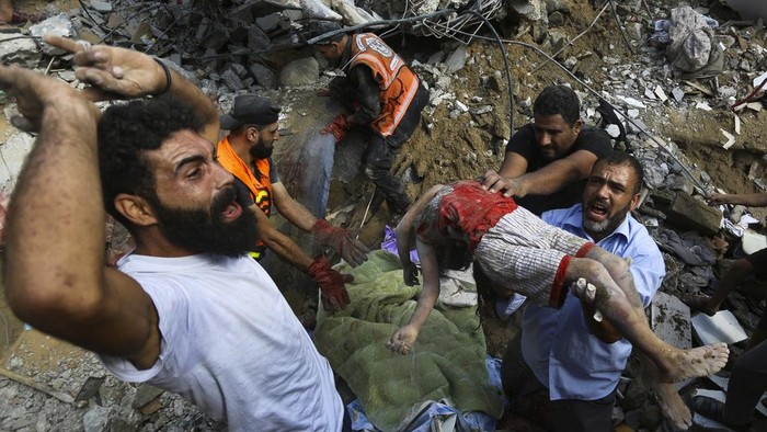Palestinians carry a body of a dead child who was found under the rubble of a destroyed house after Israeli airstrikes on Gaza City, Tuesday, Oct. 24, 2023. (AP Photo/Abed Khaled)