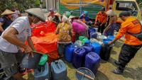 Warga mengambil air bersih yang didistribusikan menggunakan jeriken. 