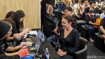 Rianti mengambil iPhone 15 Pro Max pesanannya sambil dilayani langsung oleh Kusumo. Foto: Virgina Maulita Putri/detikINET