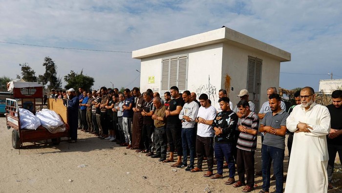 Mourners pray next to the bodies of Palestinians killed in Israeli strikes, during their funeral, as the conflict between Israel and Palestinian Islamist group Hamas continues, in Khan Younis, in the southern Gaza Strip, October 27, 2023. REUTERS/Ibraheem Abu Mustafa