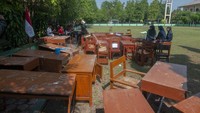 Sejumlah siswa beristirahat usai membersihkan ruang kelas yang mengalami kerusakan pada bagian atap plafon di SMA Negeri 1 Wonosari, Klaten, Jawa Tengah, Jumat (27/10/2023). 