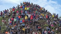 Mereka berkumpul hingga memenuhi puncak bukit untuk menyaksikan suatu peristiwa yang menjadi daya tarik wisata.