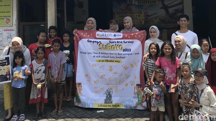 Anak muda bagi-bagi susu kepada anak-anak kurang beruntung di Surabaya dalam rangka memperingati Hari Sumpah Pemuda.