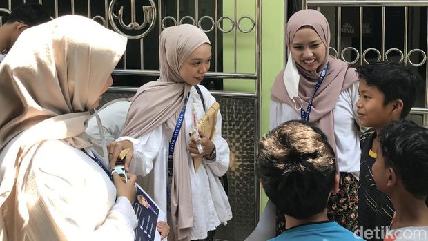 Anak muda bagi-bagi susu kepada anak-anak kurang beruntung di Surabaya dalam rangka memperingati Hari Sumpah Pemuda.