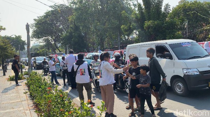 Relawan Ganjar Pranowo membagikan ribuan tangkai bunga di jalanan Jakarta (Mulia/detikcom)