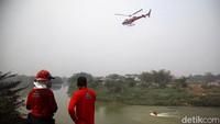 Helikopter dari Badan Nasional Penanggulangan Bencana (BNPB) mengambil air di Sungai Cisadane untuk melakukan water bombing. Sungai itu berada di sisi luar TPA Rawa Kucing.  
