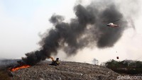 Helikopter dari Badan Nasional Penanggulangan Bencana (BNPB) bersiap melakukan water bombing pada titik api. Titik api berpindah-pindah tergantung titik panas dan angin. Kolam air pun menghitam dipadati jelaga.