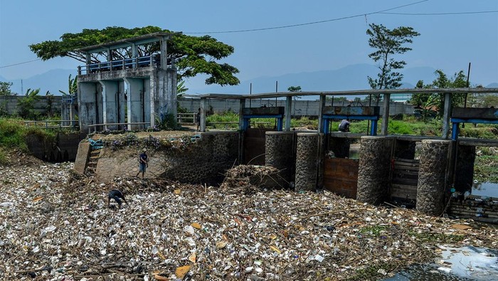 Warga berada diantara tumpukan sampah yang menumpuk di Sungai Citarik, Rancaekek, Kabupaten Bandung, Jawa Barat, Sabtu (28/10/2023). Warga menyatakan sudah hampir seminggu sampah yang didominasi oleh plastik dan styrofom tersebut menumpuk di Sungai Citarik dan warga berharap agar dinas terkait segera mengangkut sampah tersebut karena khawatir akan penyakit yang ditimbulkan. ANTARA FOTO/Raisan Al Farisi/hp.