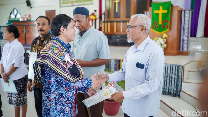 Wamen ATR/BPN Raja Juli saat menyerahkan sertifikat tanah kepada warga (Belia/detikcom)