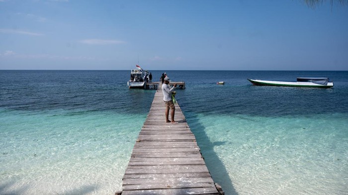 Wisatawan berjalan menaiki perahu cepat yang akan mengangkutnya ke sejumlah kawasan wisata pulau di Pantai Teluk Lalong, Kabupaten Banggai, Sulawesi Tengah, Minggu (29/10/2023). Pemerintah setempat mendorong pihak swasta untuk ambil bagian dalam mendukung program pengembangan wisata berbasis alam kepulauan di wilayah itu terutama dalam hal penyediaan sarana transportasi wisata antarpulau. ANTARA FOTO/Basri Marzuki/nz
