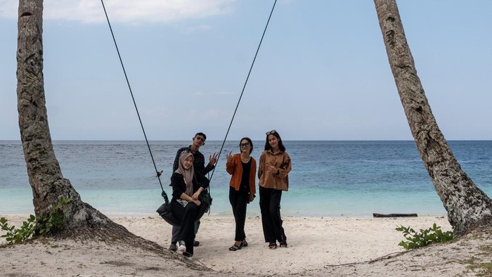 Pesona Wisata Pantai Poganda di Banggai Kepulauan Sejumlah wisatawan menikmati suasana pantai saat berwisata di Pantai Poganda, Desa Lukpanenteng, Kabupaten Banggai Kepulauan (Bangkep), Sulawesi Tengah, Minggu (29/10/2023). Hamparan pasir putih dengan rerimbunan pohon kelapa di sekitarnya dan ekosistem laut yang masih asli menjadi daya tarik tersendiri sehingga kawasan wisata alam pantai yang hanya dapat dijangkau dengan sarana transportasi laut ini menjadai salah satu tujuan wisata di wilayah itu. ANTARA FOTO/Basri Marzuki/nz