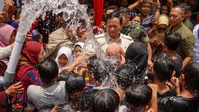 Menhan Prabowo Subianto (tengah) menikmati kucuran air bersih bersama warga yang dihasilkan dari instalasi sumur bor bantuan dari Kementrian Pertahanan di Desa Suro, Kalibagor, Banyumas, Jateng, Minggu (29/10/2023). Kementrian Pertahanan melalui Unversitas Pertahanan telah mengeksplorasi dan membangun sumur bor dan instalasi air di 73 titik yang telah menjangkau 12 ribu kk di seluruh indonesia. ANTARA FOTO/Idhad Zakaria/YU