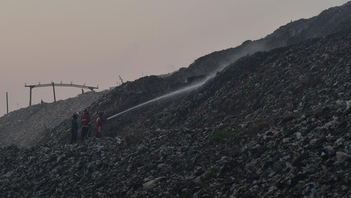 Potret Sisa-sisa Kebakaran di TPST Bantargebang Bekasi Sejumlah petugas menggunakan eskavator melakukan proses pendinginan TPST (Tempat Pembuangan Sampah Terpadu) Bantargebang, Bekasi, Jawa Barat, Minggu (29/10/2023). Menurut keterangan Dinas Lingkungan Hidup (DLH) DKI Jakarta sebanyak 19 mobil pemadam dikerahkan untuk memadamkan api pada kebakaran yang terjadi pada pukul 13.30 WIB dan penyebab kebakaran di zona 2 TPST tersebut masih dalam penyelidikan. ANTARA FOTO/ Fakhri Hermansyah/nz
