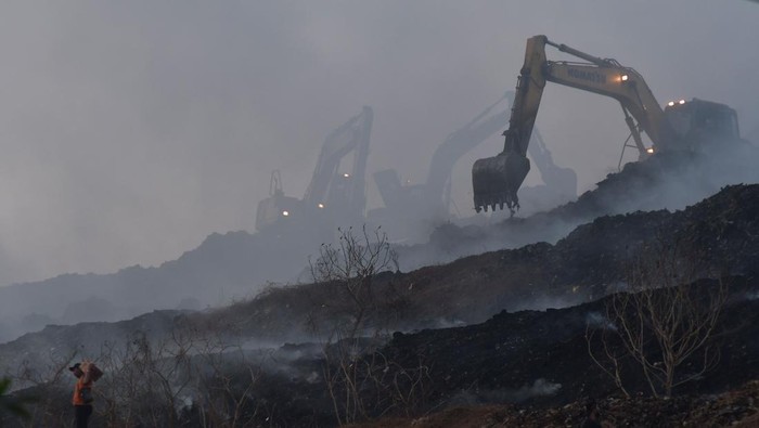 Sejumlah petugas menggunakan eskavator melakukan  proses pendinginan TPST (Tempat Pembuangan Sampah Terpadu) Bantargebang, Bekasi, Jawa Barat, Minggu (29/10/2023). Menurut keterangan Dinas Lingkungan Hidup (DLH) DKI Jakarta sebanyak 19 mobil pemadam dikerahkan untuk memadamkan api pada kebakaran yang terjadi pada pukul 13.30 WIB dan penyebab kebakaran di zona 2 TPST tersebut masih dalam penyelidikan. ANTARA FOTO/ Fakhri Hermansyah/nz
