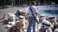 Seorang tentara Israel yang sedang tidak bertugas mengambil foto instalasi boneka beruang raksasa dengan mata tertutup dan dihiasi foto warga Israel yang ditawan di Gaza, di Tel Aviv. Instalasi tersebut dimaksudkan untuk menarik perhatian lebih dari 200 orang yang diculik oleh militan Hamas dalam serangan lintas batas tanggal 7 Oktober yang berdarah dan belum pernah terjadi sebelumnya. 