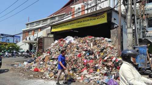 Sampah berjibun hingga ke jalan di Depo Sampah Jalan Pulau Seram, Desa Dauh Puri Kelod, tepatnya di sebelah pintu barat Level Twenty One Mall, Kota Denpasar. Warga yang melintas di depan TPS dengan berjalan kaki harus memakai badan jalan.