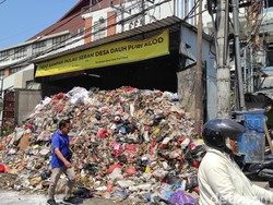 Sampah berjibun hingga ke jalan di Depo Sampah Jalan Pulau Seram, Desa Dauh Puri Kelod, tepatnya di sebelah pintu barat Level Twenty One Mall, Kota Denpasar. Warga yang melintas di depan TPS dengan berjalan kaki harus memakai badan jalan. (Foto: I Wayan Sui Suadnyana/detikBali)