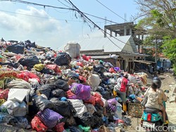 Tumpukan sampah paling tinggi terlihat di TPS Desa Adat Batuyang, Jalan Cok Agung Tresna 2, Kota Denpasar. Sampah di lokasi ini bahkan meluber hingga memakan setengah badan jalan. Seorang pengendara sepeda motor tampak kesulitan untuk lewat di jalan tersebut akibat sampah yang meluber menutupi setengah badan jalan. (Foto: I Wayan Sui Suadnyana/detikBali)